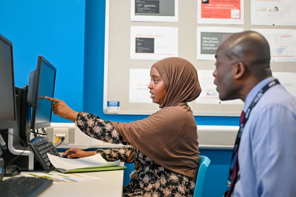 Students and teacher looking at a screen