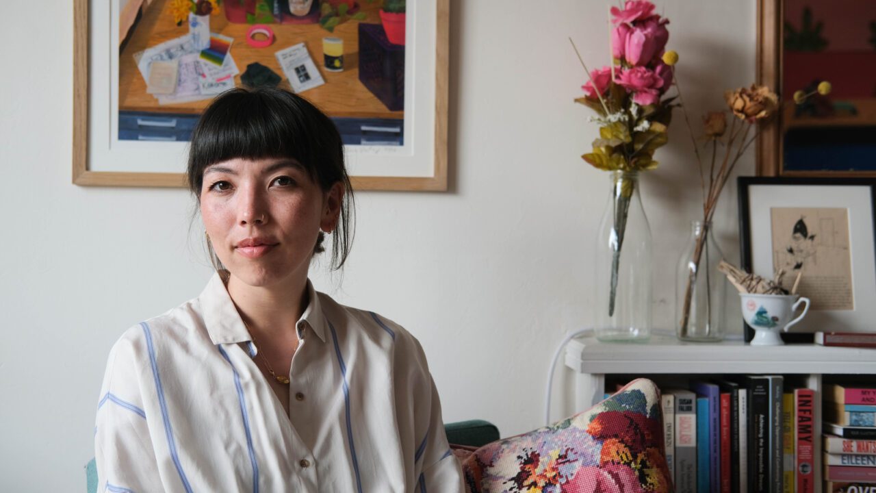 Woman in living room with flowers and a painting in the background