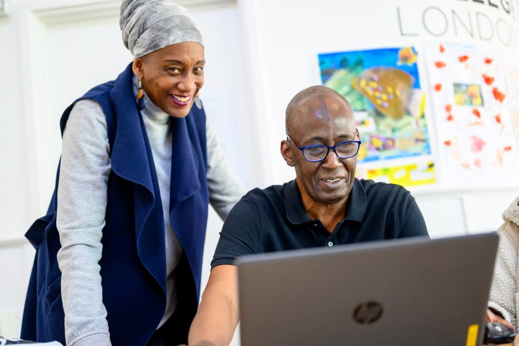 Older male student with teacher in classroom