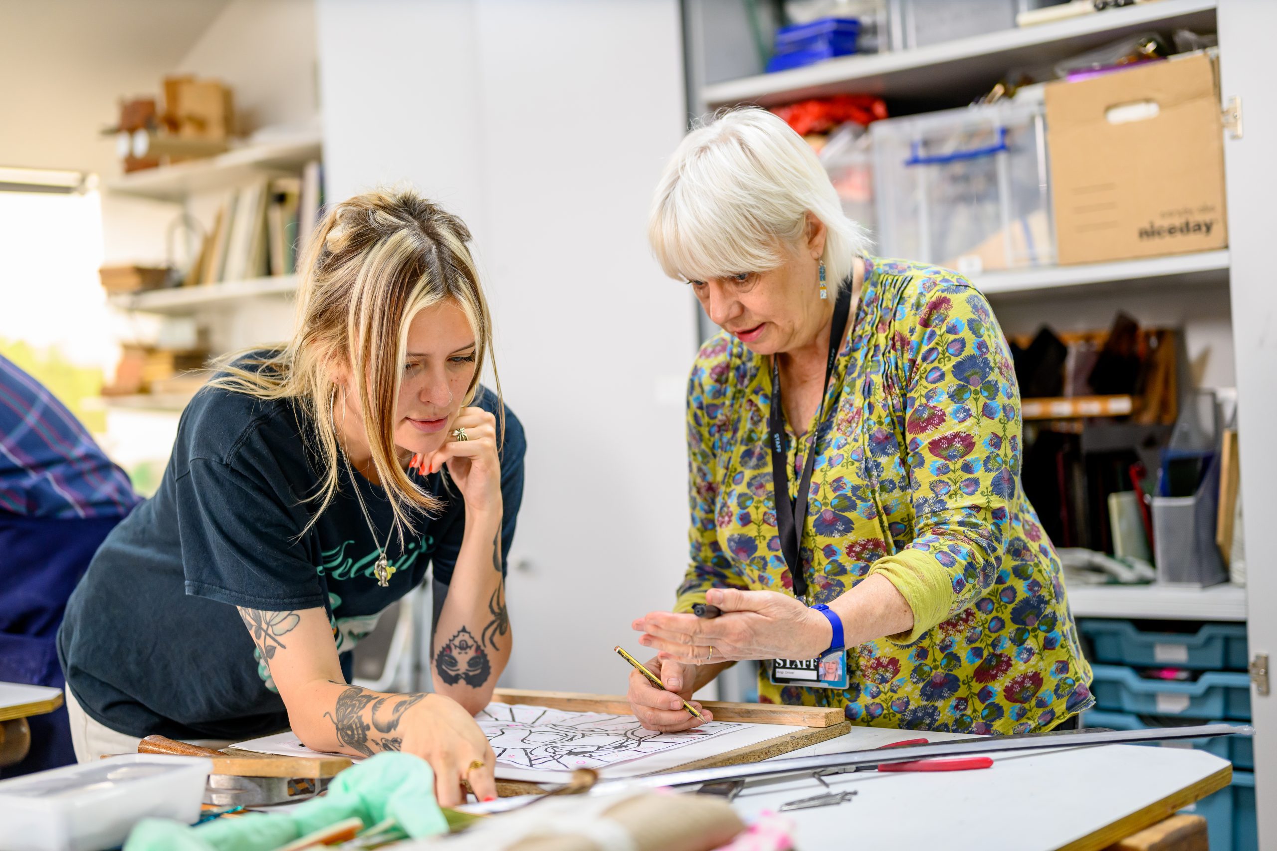 Two women in glass studio.